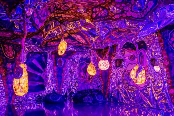 immersive art exhibit featuring a purple alien landscape